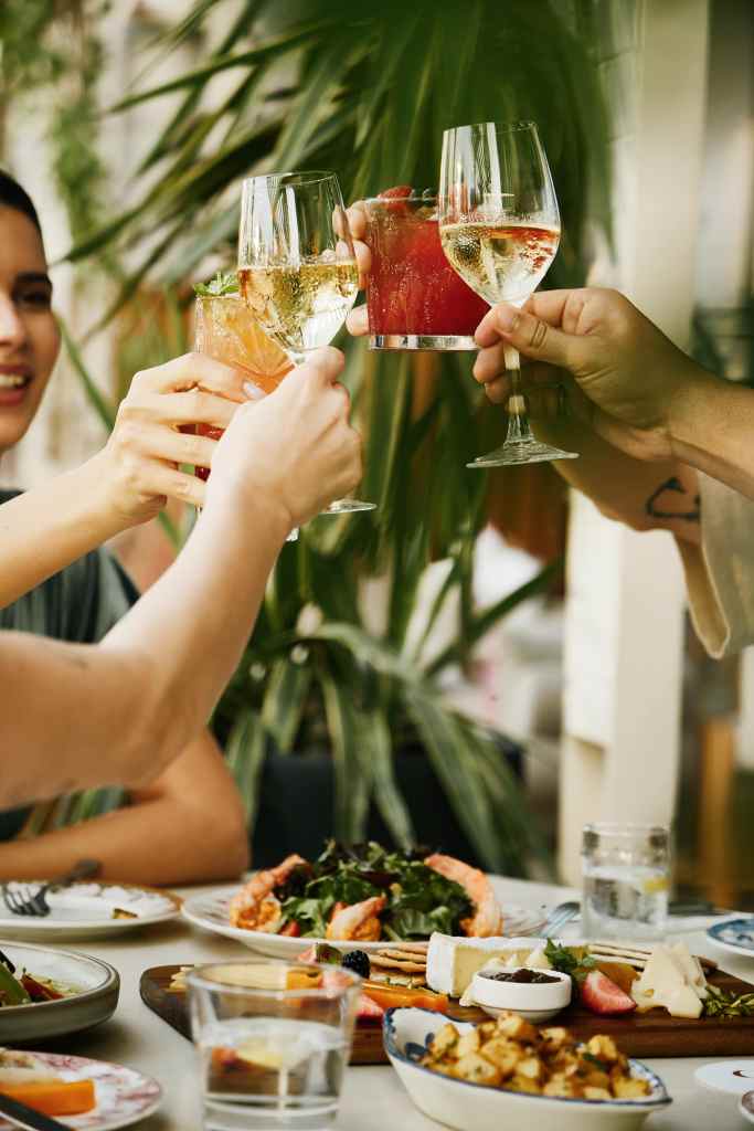 group happily clinking their cocktail glasses.